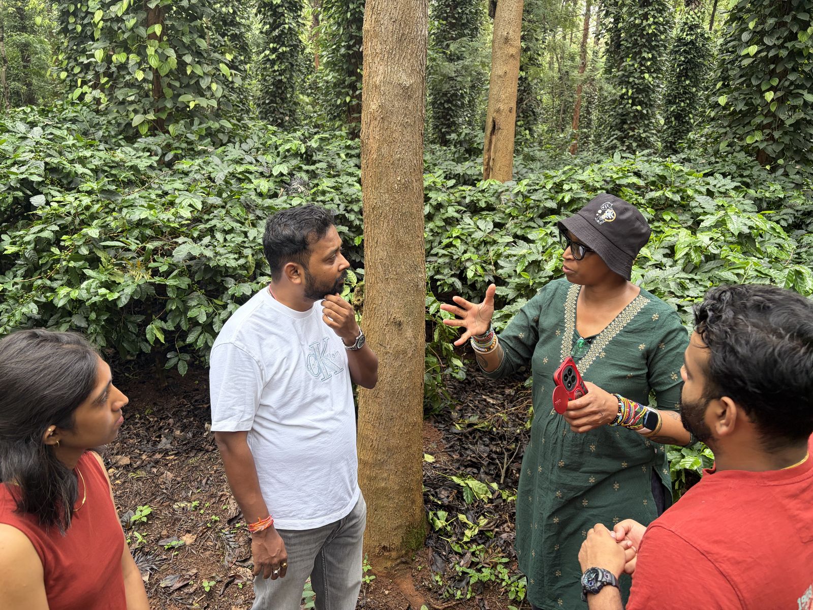 Field session discussing cherry maturity with tribal planters under shade trees